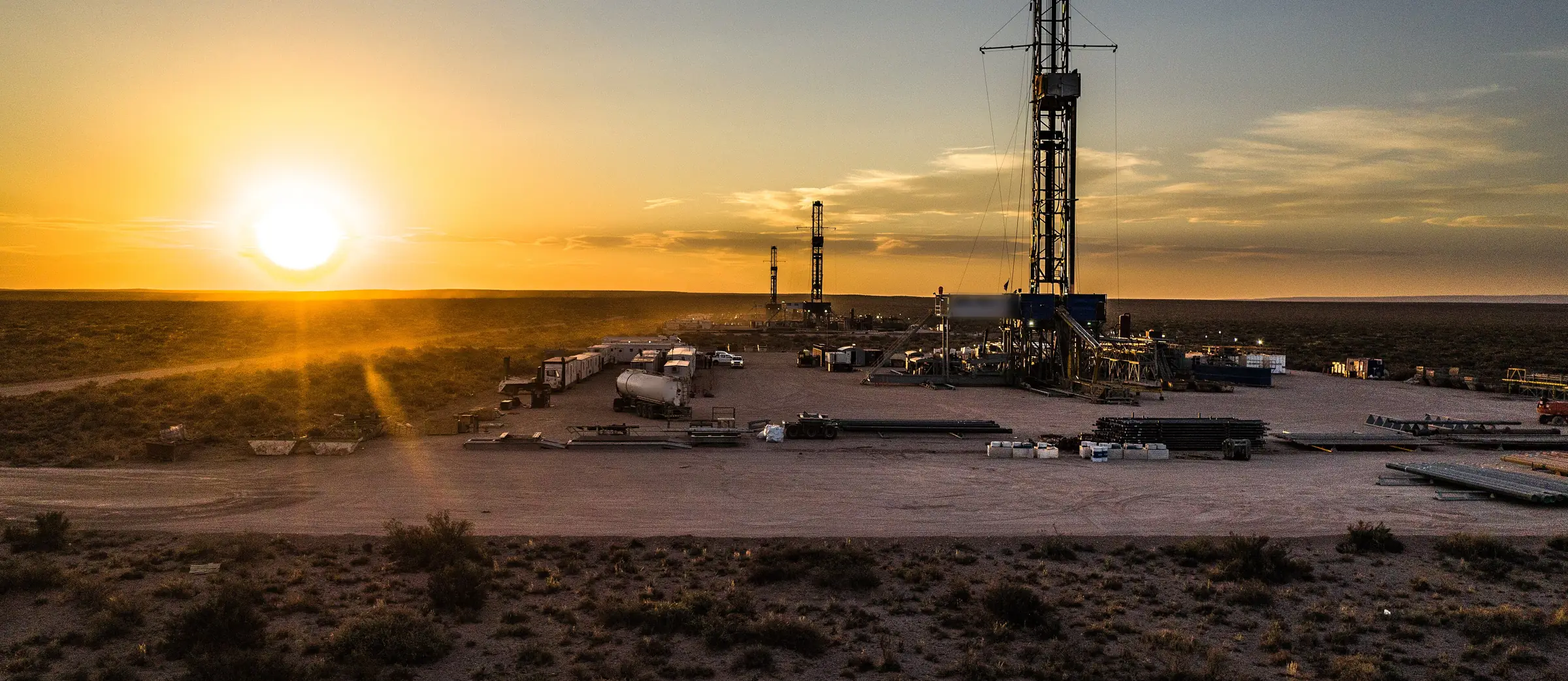 Equipos de perforación al atardecer en una locación de Vaca Muerta, Neuquén